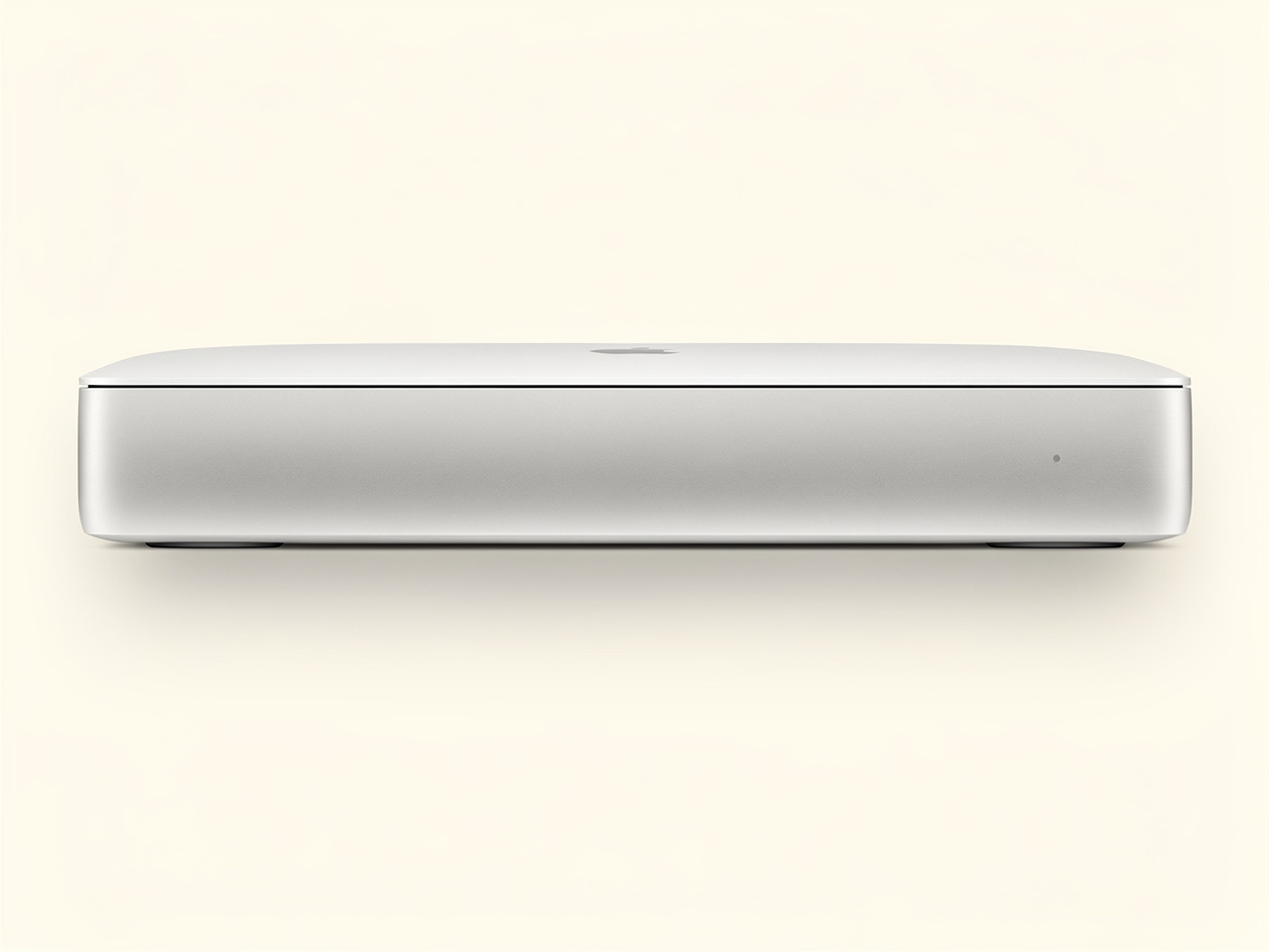 A sleek silver Apple Mac mini viewed from the front, showing its rounded aluminum body and tiny indicator light.